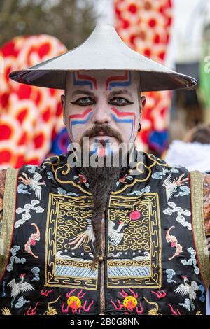 Dietfurt, Germania. 20th Feb, 2020. Un uomo in costume cinese partecipa alla tradizionale processione cinese del carnevale. Come ogni anno il 'Senza Senso Giovedi', stolti vestiti come asiatici sfilano attraverso la città. Il carnevale cinese risale ad una leggenda secondo la quale il popolo di Dietfurt nel Medioevo ha semplicemente lasciato un esattore fiscale che si erge fuori dalle mura della città. Si dice che il camberlain si sia successivamente lamentato al vescovo, suo datore di lavoro, che i Dietfurters si nascondevano dietro il loro muro 'come i cinesi'. Credito: Armin Weigel/Dpa/Alamy Live News Foto Stock