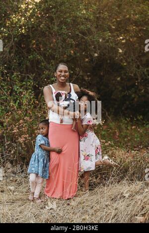 Ritratto di giovane madre e tre ragazze in piedi sul campo Foto Stock