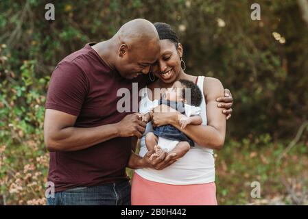 Primo piano madre felice e padre coccolante neonata ragazza Foto Stock