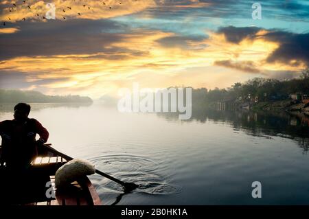 silhouette di boatsman canottaggio nel fiume yamuna ganga al mattino Foto Stock