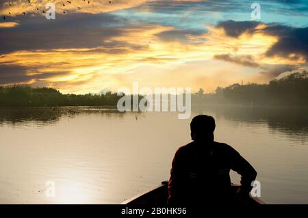 silhouette di boatsman canottaggio nel fiume yamuna ganga al mattino Foto Stock