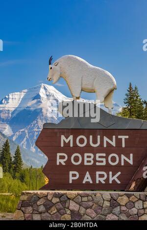 Cartello d'ingresso con scolpito Mountain Goat e il Monte Robson che torreggia dietro, nel Mount Robson Provincial Park, British Columbia, Canada Foto Stock