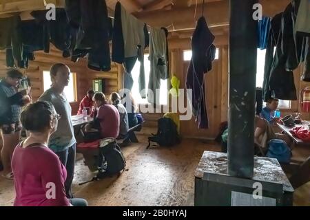 Gli escursionisti che asciugano gli attrezzi bagnati durante la pioggia a Harraves Shelter sul Lago Berg nel Parco Provinciale di Mount Robson, British Columbia, Canada [Nessun modello rel Foto Stock