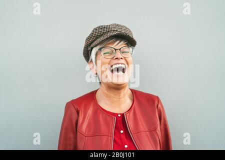 Felice Senior donna ridere all'aperto - Trendy persona matura divertirsi durante il tempo in pensione - Anziani stile di vita concetto Foto Stock