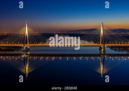 Budapest, Ungheria - veduta aerea del Ponte Megyeri illuminato al tramonto con cielo blu chiaro Foto Stock