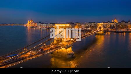 Budapest, Ungheria - veduta panoramica aerea del famoso Ponte delle catene Szechenyi illuminato a un'ora blu con il palazzo del Parlamento e i Basi di Santo Stefano Foto Stock