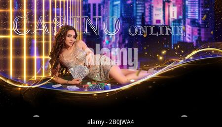 Donna in abito dorato. Tenere un po 'di contanti, posando sdraiato sul tavolo da gioco verde con pile di chip, carte su di esso. Sfondo urbano. Poker, casinò Foto Stock