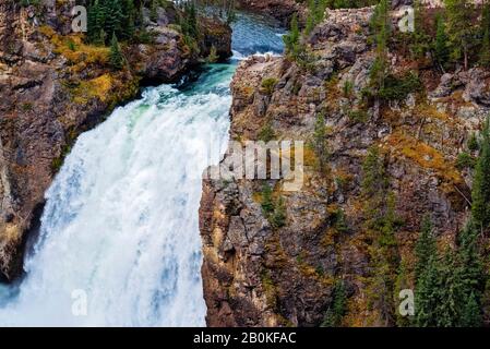 Acqua bianca in rapido movimento che scorre sulla scogliera. L'acqua cade con alberi verdi. Foto Stock