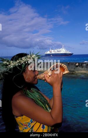 ISOLE COOK, ISOLA DI ATIU, SCOPRITORE MONDIALE MS, RAGAZZA CHE SOFFIA IN SEASHELL (CORNO) Foto Stock