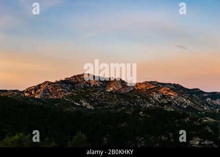 Alba a Calanque de Morgiou (Marsiglia, Francia): Il paesaggio mozzafiato di montagna scogliera sotto la calda luce solare soffusa Foto Stock