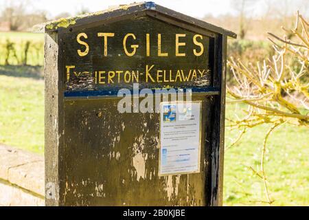 Una bacheca scarsamente popolata che fornisce dettagli sul clero e sui tempi di culto nella chiesa di St Giles a Kellaways vicino a Chippenham Wiltshire Engla Foto Stock