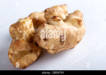 Fresh topinambur sul vecchio tavolo in legno. Foto Stock