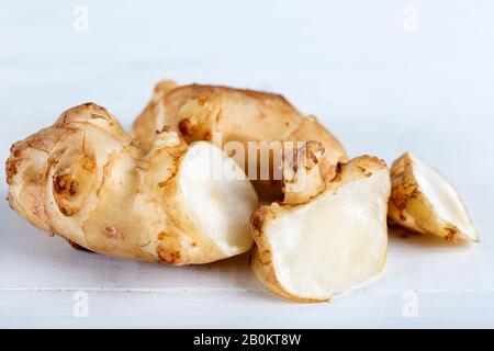 Fresh topinambur sul vecchio tavolo in legno. Foto Stock