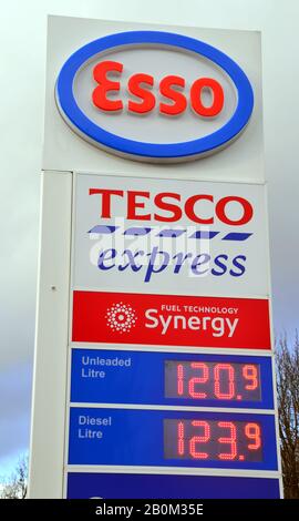 Un cartello che mostra i prezzi del gasolio e della benzina senza piombo in un garage Tesco Express con il marchio esso di Ardwick, Manchester, Regno Unito Foto Stock