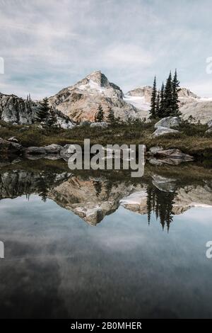 Scena alpina di montagna che riflette nella calma tarn Foto Stock