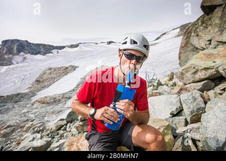 Acqua alpinista da bottiglia con un filtro collegato. Foto Stock