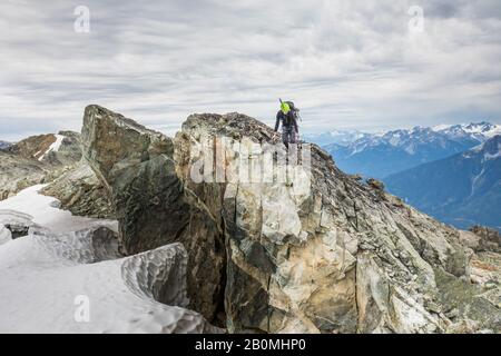 Backpacker escursioni attraverso crinale rocciosa in B.C. Foto Stock