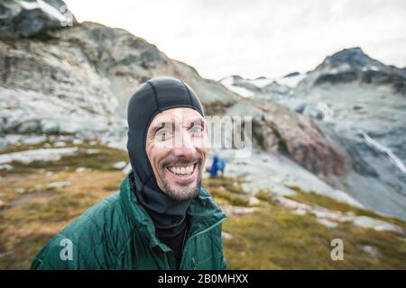 Ritratto di uomo sorridente durante il viaggio escursionistico Foto Stock