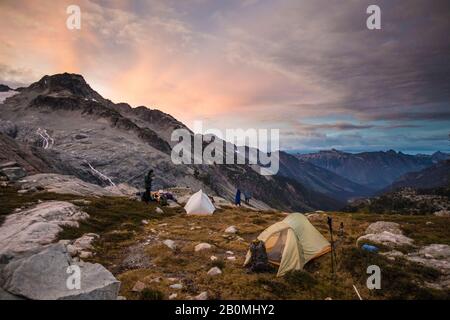 Scalatori campeggio in un prato alpino sotto la montagna. Foto Stock