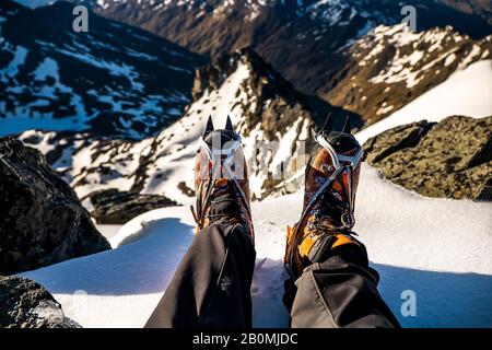 scarponi da alpinismo con ramponi in cima a una cima di montagna Foto Stock