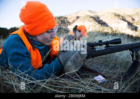 Due cacciatori femmina prepararono i loro fucili per sparare l'alce in Colorado Foto Stock