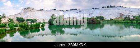 Pamukkale, Turchia – 07.15.2019. Montagna bianca e lago verde a Pamukkale. Vista panoramica dal lato del villaggio in una mattinata estiva Foto Stock