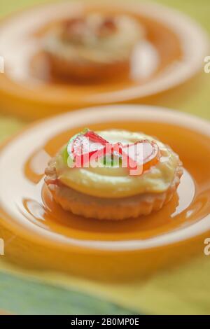 Dolce torta rotonda con crema e gelatina rossa cocomero fette in arancio piatto sul tavolo Foto Stock