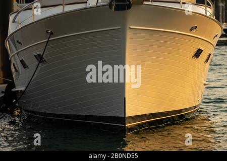 Yacht a motore prua in acqua vista di fronte al tramonto Foto Stock