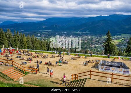 Terrazze solarium sul monte Gubałówka, dove il turista gode della vista panoramica della località montana Zakopane, sulle montagne Tatra della piccola Polonia Foto Stock