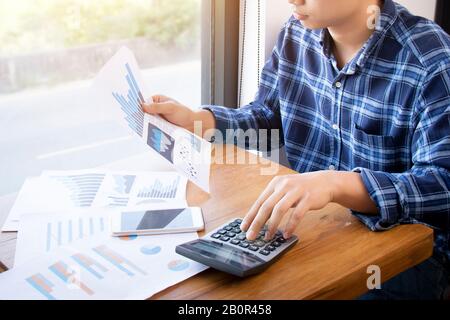 Business contabilità persone, risparmio, finanza e concetto di economia. Uomo d'affari asiatico serio usando la calcolatrice per i documenti di calcolo, grafici Foto Stock