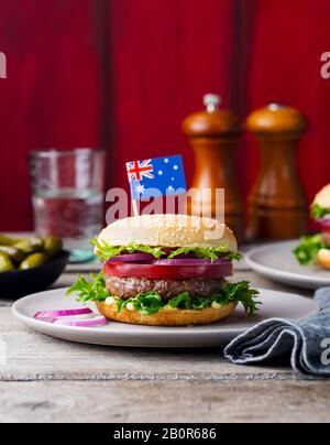 Burger con bandiera australiana in cima. Sfondo in legno. Spazio di copia. Foto Stock