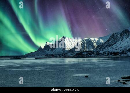 Aurora Borealis, l'aurora boreale Sopra la montagna innevata nelle isole Lofoten in Norvegia Foto Stock