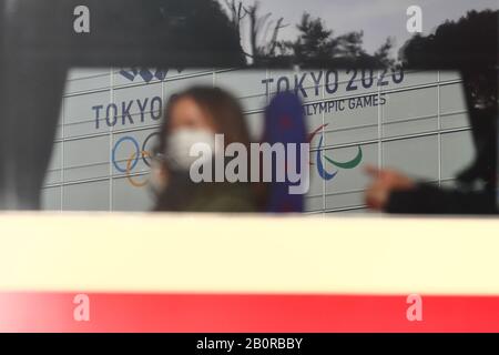 I passeggeri del treno indossano maschere facciali protettive, in quanto i banner olimpici di Tokyo 2020 sono esposti a Shinagawa, Tokyo, Giappone, il 19 febbraio 2020. Credit: Naoki Nishimura/Aflo Sport/Alamy Live News Foto Stock