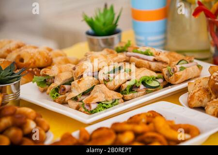 buffet per festeggiare il compleanno cibo su piatti, panini fatti in casa e decorazioni Foto Stock