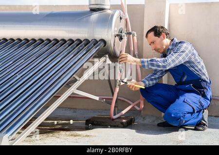 Idraulico Maschio Riparazione Energia Solare Caldaia Elettrica Foto Stock