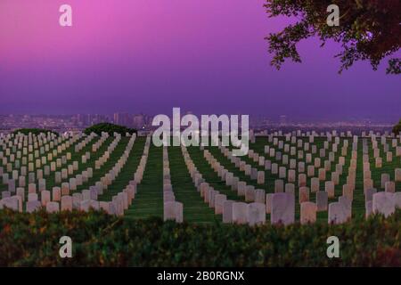 Cimitero di guerra americano con file di cimitero a Point Loma, California, Stati Uniti con i grattacieli del centro di San Diego sullo sfondo Foto Stock