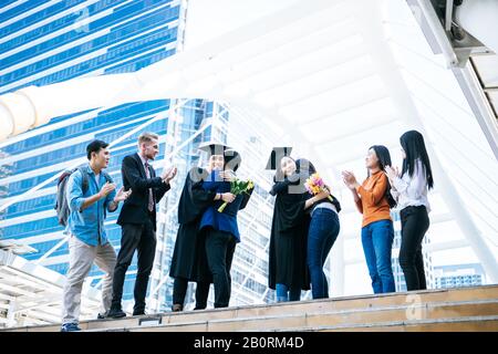 Gli studenti asiatici si sono congratulati con il loro genitore durante la cerimonia di laurea Foto Stock