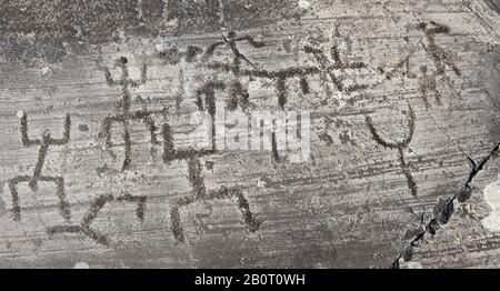 Petroglyph, scultura in roccia, di un grande gruppo di figure umane schematiche nella cosiddetta posizione di preghiera. Scolpito dagli antichi Camunni nel Foto Stock