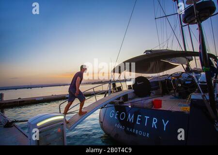 18/09/2015 Siracusa , Italy Young Handsome sailor sorge su un lussuoso yacht A vela E tramonto Foto Stock