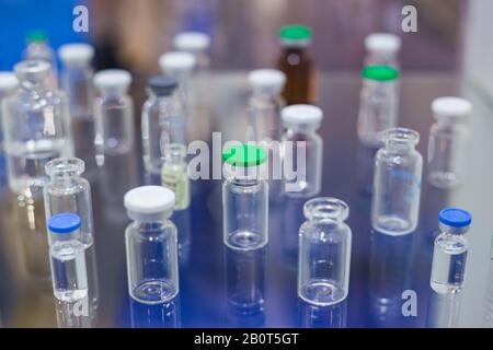 Medical svuotare le bottiglie di vetro in vetrina alla fiera farmaceutica Foto Stock