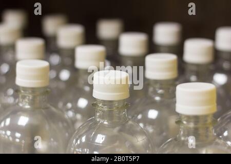 Nuove bottiglie in plastica con coperchi per il riempimento di acqua e bevande Foto Stock