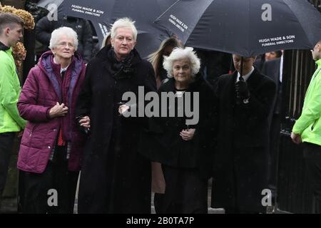 I membri della famiglia e i lutto arrivano per i funerali dell'ex portiere del Manchester United e dell'Irlanda del Nord Harry Gregg, presso la chiesa parrocchiale di San Patrizio, Coleraine. Foto Stock