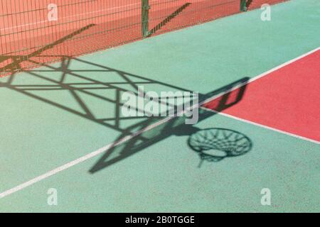 Ombra di cerchio di basket sullo sfondo colorato campo. Foto Stock