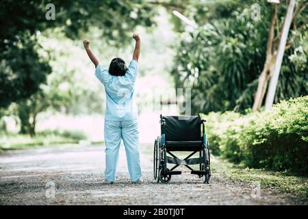 Terapia fisica donna anziana con sedia a rotelle nel parco Foto Stock