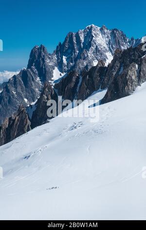 Paesaggio scosso dalla stazione della funivia di Punta Helbronner in una giornata di sole con cielo blu e alpinisti sul ghiacciaio Foto Stock