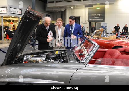 Persone che guardano le auto il giorno di apertura del 2020 London Classic Car Show, Londra Olympia, Regno Unito. Oltre 500 delle più belle automobili e marchi classici del mondo, del valore di £70 milioni, sono in mostra allo spettacolo che va dai tour vintage prima della guerra ad un concept car moderno. Lo spettacolo porta in circa 20.000 visitatori, che vanno da gravi teste di benzina a persone che amano solo veicoli belli e classici. Foto Stock