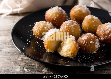 Frittelle di Carnevale o buñuelos de viento per la settimana Santa su tavola di legno Foto Stock