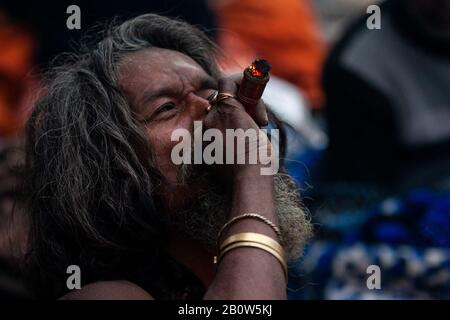 Kathmandu, Nepal. 21st Feb 2020. Kathmandu, Nepal. 21st Feb, 2020. Un sadhu (uomo sacro indù) fuma marijuana usando un 'chillum', un tradizionale tubo di argilla, durante il festival indù 'maha Shivaratri' a Kathmandu il 21 febbraio 2020. I Devoti indù del Nepal e dell'India vengono a questo tempio per partecipare al festival Shivaratri, uno dei più grandi festival indù dedicati a Lord Shiva e celebrato dai devoti di tutto il mondo (Photo by Prabin Ranabhat/Pacific Press) Credit: Pacific Press Agency/Alamy Live News Foto Stock