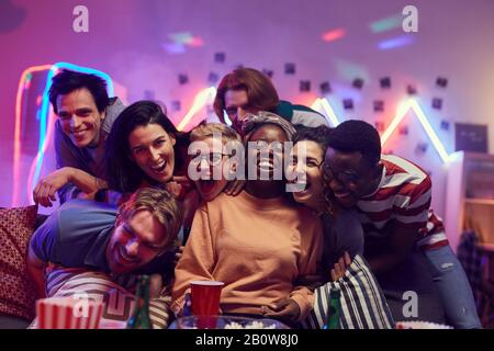 Ritratto di gruppo multietnico di giovani ridere e divertirsi insieme al partito Foto Stock