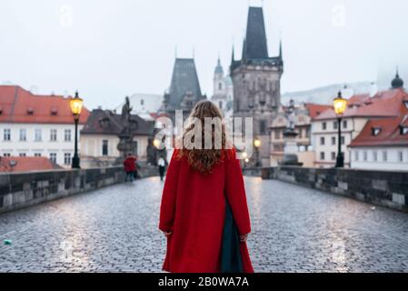 Turista femminile a piedi da solo sul Ponte Carlo durante la mattina presto a Praga, capitale della Repubblica Ceca Foto Stock